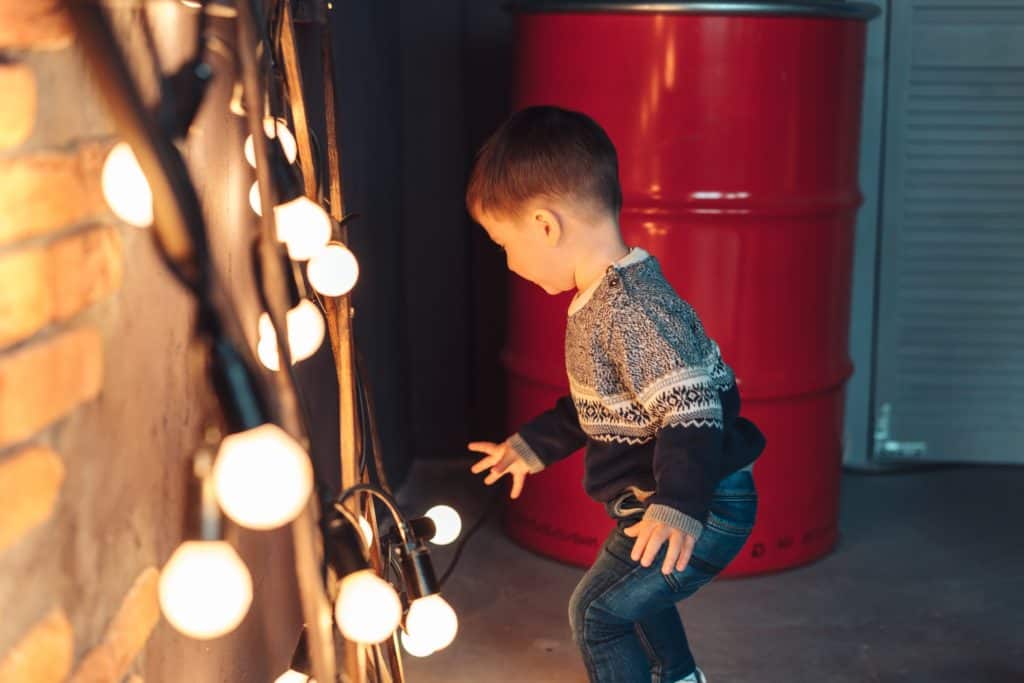 little boy plays with light bulbs